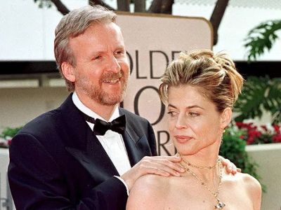 James Cameron has his hands on Linda Hamilton's shoulder from behind.